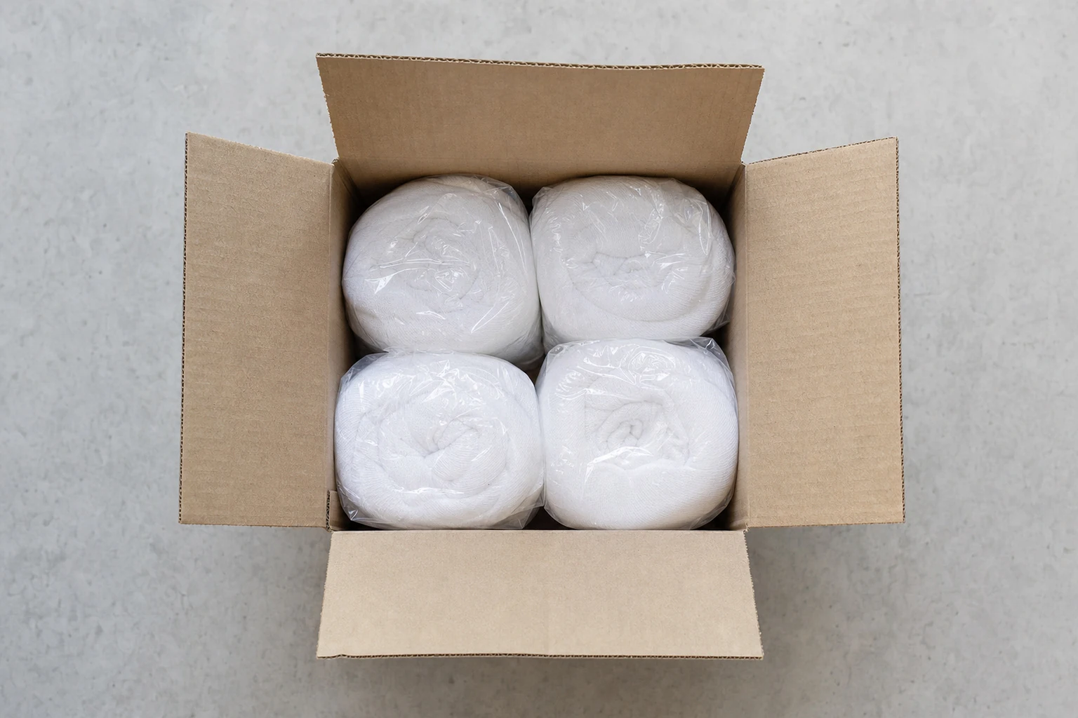 Wrapped stockinette rolls arranged in an open carton